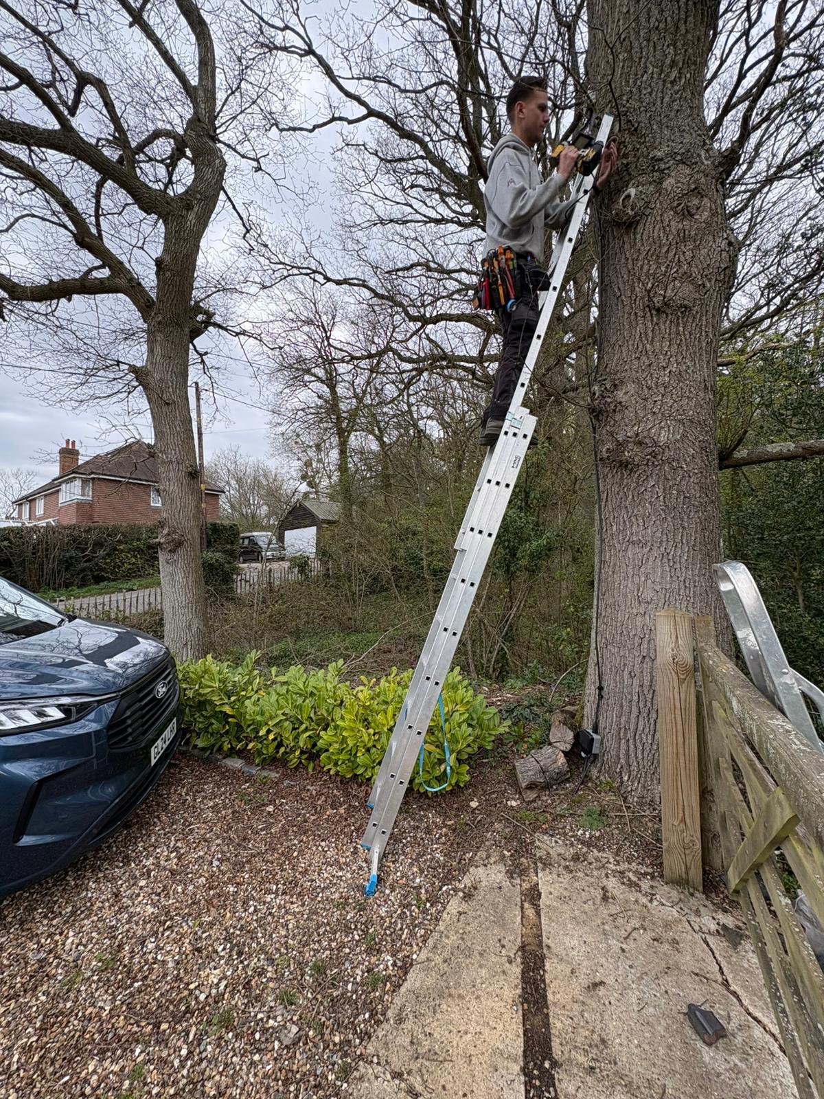 HRH Electrical electrician carrying out external electrical work from a ladder